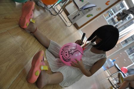 在气球上绘画的小女生（陈雨）